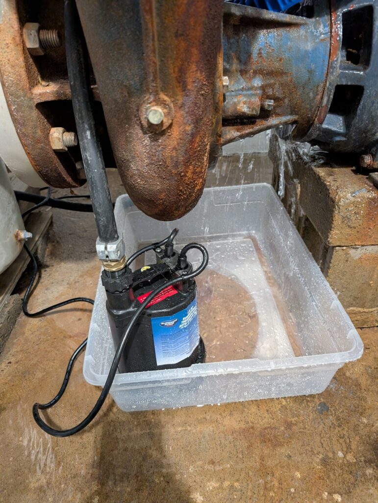 Using a small utility pump and a plastic bin to capture water from the leaky main pump.