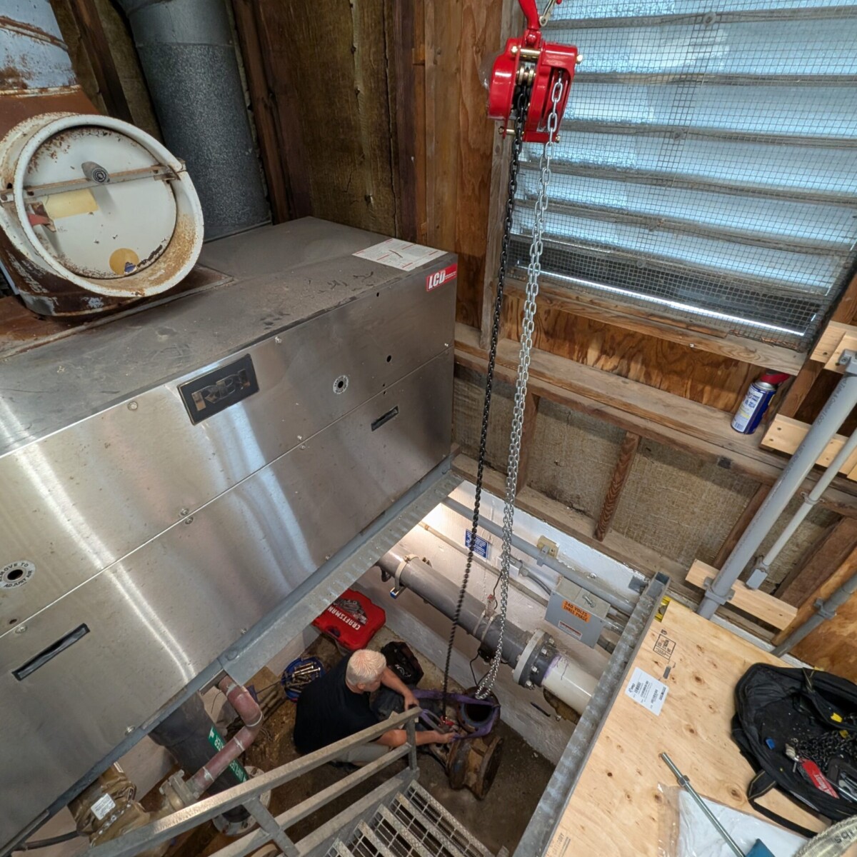 Attaching the old pump and motor to the hoist.