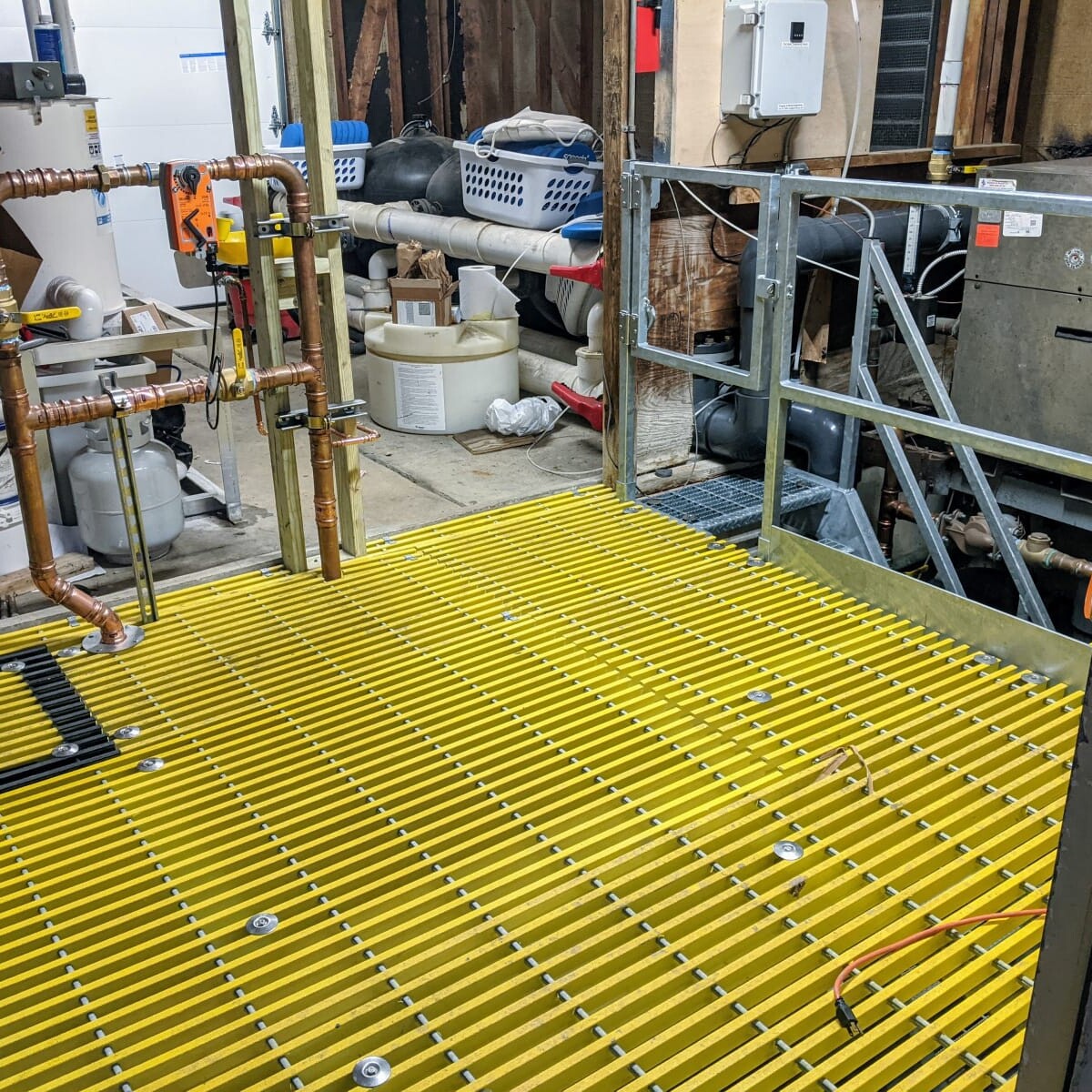 A view of the new floor (and piping) on January 11th, 2021. New Floor (View From Door)