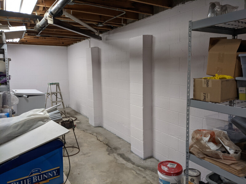 The west basement wall shortly after painting was completed. As an aside - the pilasters (vertical column-like structures) appear to have been added shortly after construction (May 1967) to help overcome hydrostatic pressure issues.Pictures do not include the stage during which extensive wall cracking/chips were repaired with hydraulic cement. West Basement Wall in May 2021