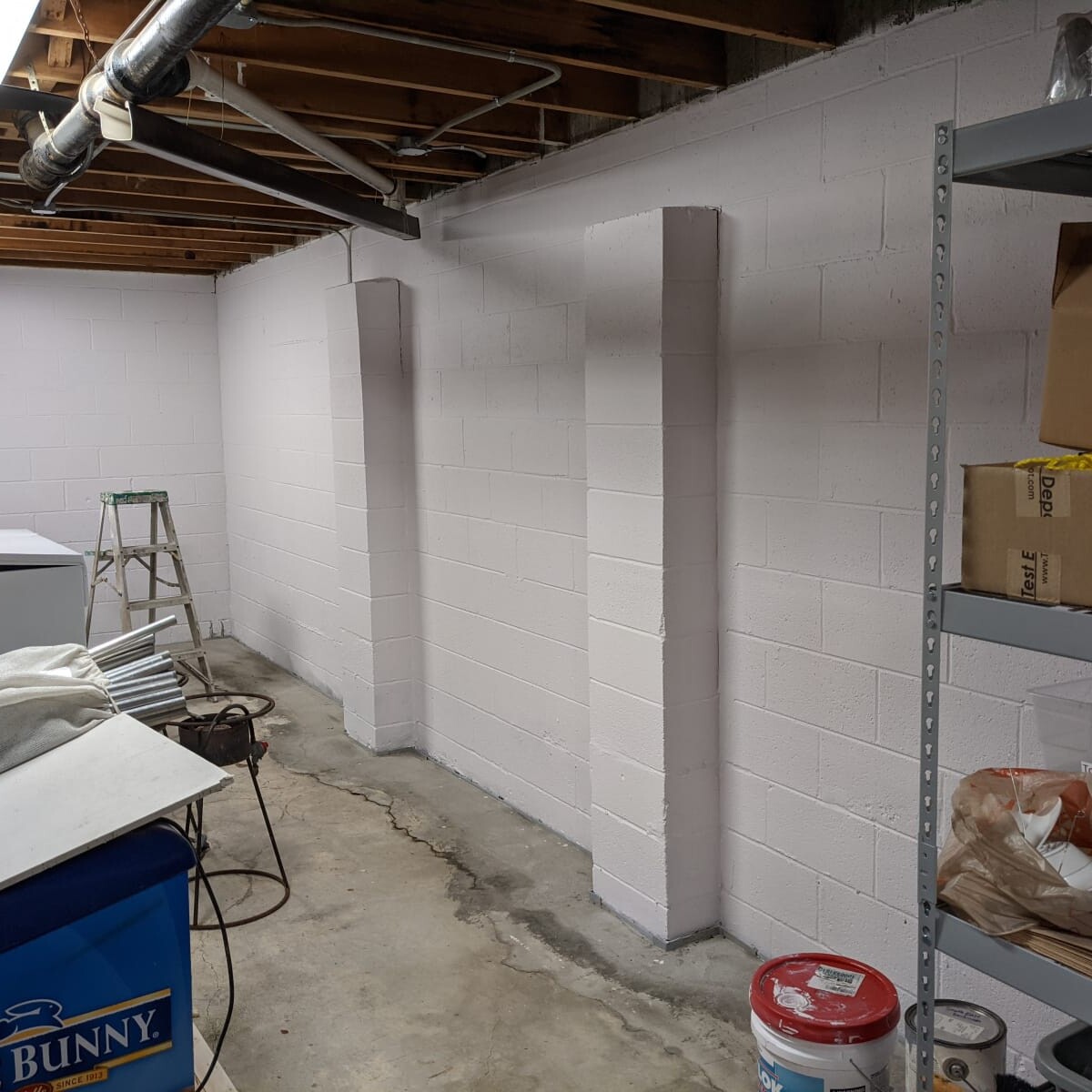 The west basement wall shortly after painting was completed. As an aside - the pilasters (vertical column-like structures) appear to have been added shortly after construction (May 1967) to help overcome hydrostatic pressure issues.Pictures do not include the stage during which extensive wall cracking/chips were repaired with hydraulic cement. West Basement Wall in May 2021