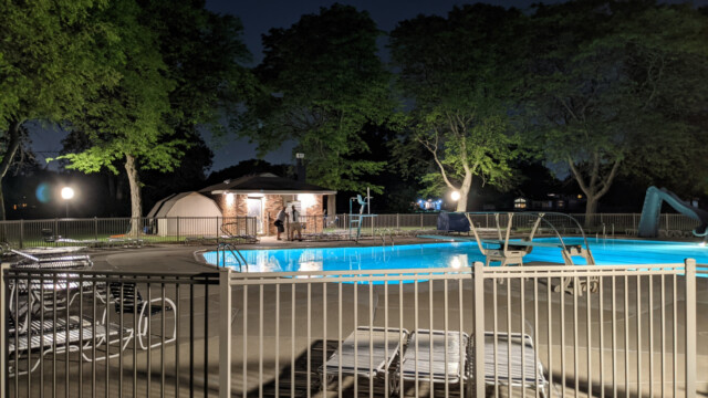 A view of the pool deck at night on May 24th, 2021. The new pump house soffit lights are also visible in the photo. Pool Deck at Night in May (1 of 7)