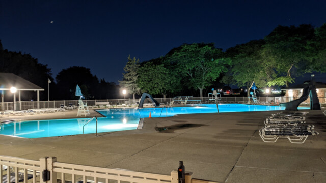 A view of the pool deck at night on June 10th, 2021. The new pump house soffit lights are also visible in the photo. Pool Deck at Night in June (2 of 2)