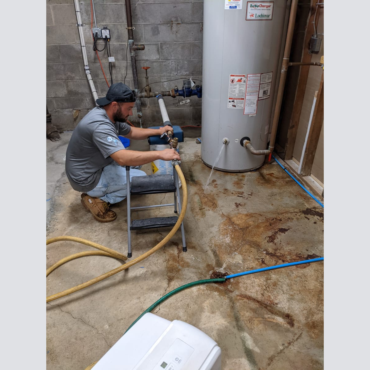 A technician from Aquatic Source is carefully using forced air to push water out of the clubhouse pipes. Blowing out the Pipes