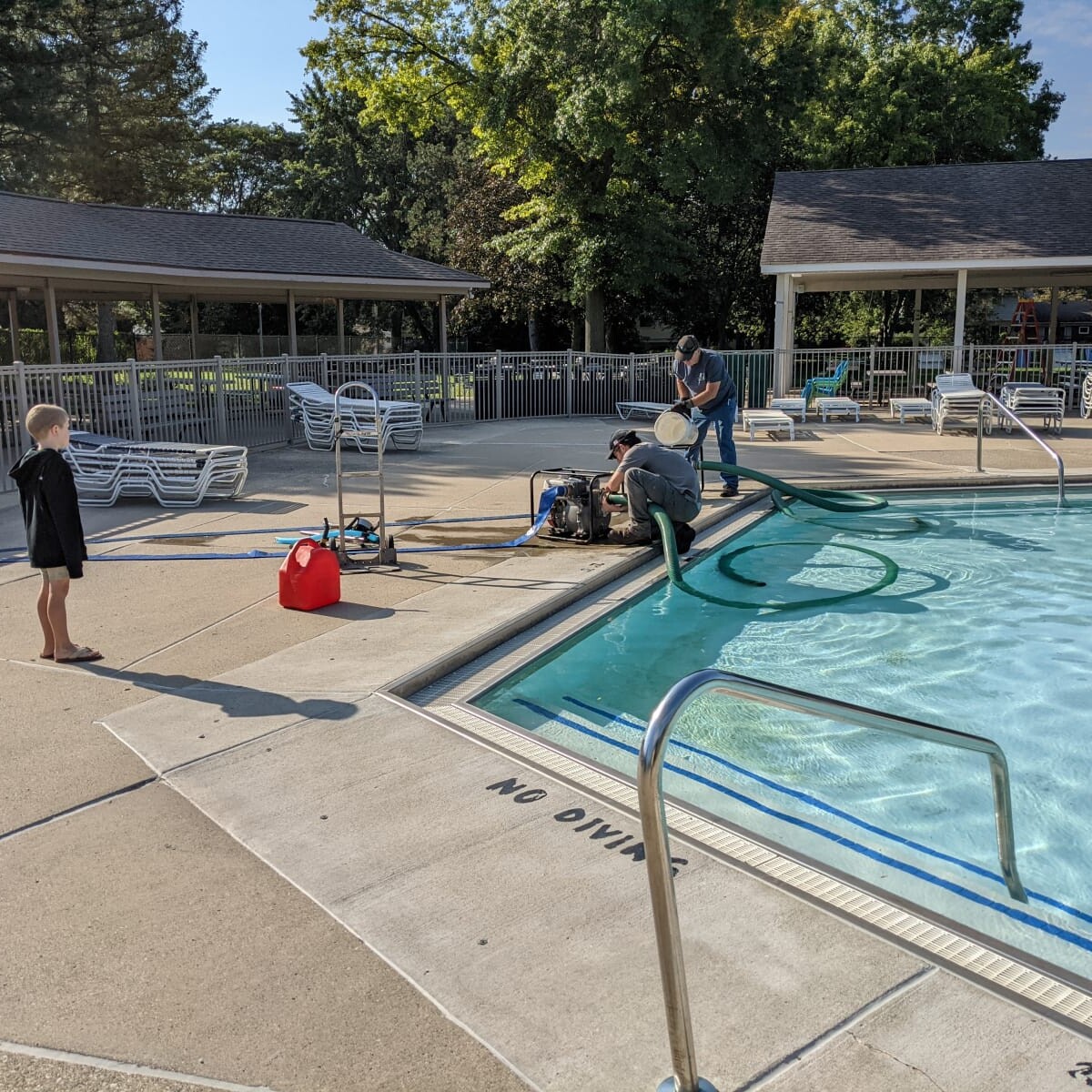 Two pumps are being set up to pull water out of the pool to drain into the parking lot. Setting up the Pumps