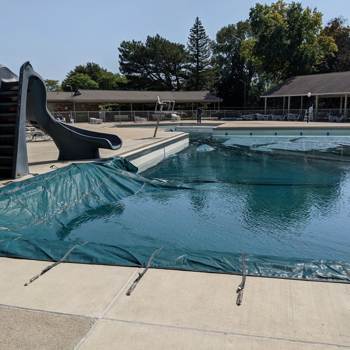 The cover is almost fully placed onto the pool. Covering the Pool (2 of 2)