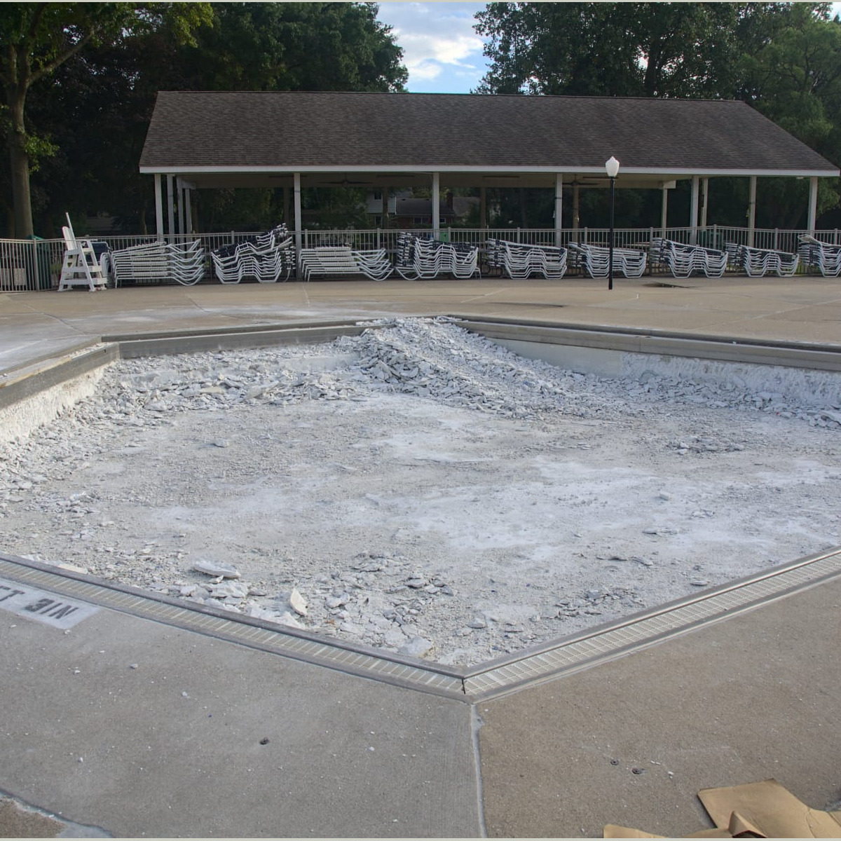 A stack of debris in the "baby pool". The technique here was later changed (per repeated requests by B&G) to avoid damage to the gutter tray and grates from marcite debris. This ramp was used for the small loader to drive into and out of the pool. Demolition - Day 6
