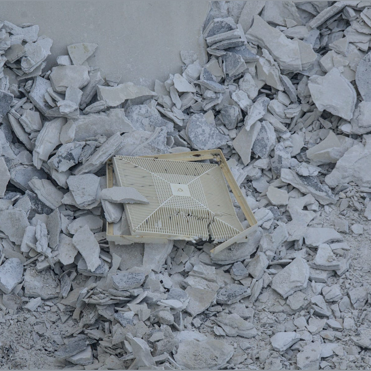 One of the floor drain covers in a pile of debris. Demolition - Day 6
